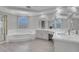 Bright bathroom featuring dual sinks, a soaking tub, and a separate glass enclosed shower at 3604 N Campbell Rd, Las Vegas, NV 89129