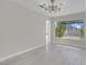Bright dining room with a modern chandelier, light wood floors, and a view of the backyard pool at 3604 N Campbell Rd, Las Vegas, NV 89129