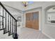 Inviting foyer with stylish light wood floors and an elegant staircase with black railing and decorative front door at 3604 N Campbell Rd, Las Vegas, NV 89129