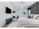 Bright bedroom featuring a modern chandelier, large mirror, accent wall, and a sleek console with a wall-mounted television at 3729 Canis Minor Ln # 10206, Henderson, NV 89052