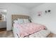 Charming bedroom featuring a tufted headboard, soft pink bedding, and a glimpse into the en-suite bathroom at 3729 Canis Minor Ln # 10206, Henderson, NV 89052