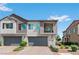 Townhouse exterior with a gray garage door, front balcony, and manicured landscaping at 3729 Canis Minor Ln # 10206, Henderson, NV 89052