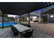 Beautiful backyard featuring a covered patio, a dining table, a pool, and a modern home exterior at 38 Skybird Ct, Las Vegas, NV 89135