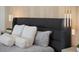 This main bedroom boasts a dark fabric headboard with pendant lights and wood paneling at 38 Skybird Ct, Las Vegas, NV 89135