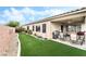 Lush backyard with artificial turf, covered patio, and well-maintained landscaping at 4015 Galiceno Dr, Las Vegas, NV 89122