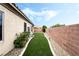 Spacious backyard with manicured artificial turf, privacy wall, and desert landscaping at 4015 Galiceno Dr, Las Vegas, NV 89122