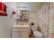 Modest bathroom featuring a single sink vanity and floral patterned shower curtain at 4565 Halbert Ave, Las Vegas, NV 89110