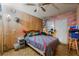 Bedroom with wood paneling, ceiling fan, and bed with a colorful quilt at 4565 Halbert Ave, Las Vegas, NV 89110
