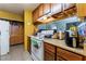 Cozy kitchen featuring wood cabinets, tile flooring, and white appliances at 4565 Halbert Ave, Las Vegas, NV 89110
