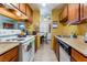 Cozy kitchen with wood cabinetry, white appliances, and tile flooring at 4565 Halbert Ave, Las Vegas, NV 89110