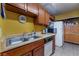 Cozy kitchen featuring wood cabinets, tile flooring, and double basin sink at 4565 Halbert Ave, Las Vegas, NV 89110