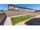 A backyard with manicured artificial turf, a brick-paved patio, and gravel landscaping, perfect for low-maintenance outdoor living at 4633 Fragrant St, North Las Vegas, NV 89031