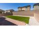 A backyard with manicured artificial turf, a brick-paved patio, and gravel landscaping, perfect for low-maintenance outdoor living at 4633 Fragrant St, North Las Vegas, NV 89031