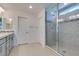 Bathroom with dual sinks, gray cabinets and a large tiled shower at 4633 Fragrant St, North Las Vegas, NV 89031
