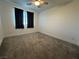 A bright bedroom featuring neutral walls, plush carpet, and a ceiling fan at 4633 Fragrant St, North Las Vegas, NV 89031