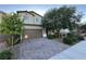 Charming two-story home featuring a well-maintained front yard and brick driveway, complemented by mature trees at 4633 Fragrant St, North Las Vegas, NV 89031