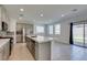 Modern kitchen with stainless steel appliances, gray cabinets, and a quartz countertop island at 4633 Fragrant St, North Las Vegas, NV 89031