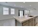 Kitchen island featuring a stainless sink, quartz countertop and gray cabinets with backyard views at 4633 Fragrant St, North Las Vegas, NV 89031