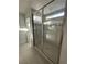 Modern walk-in shower with glass doors, grey tile, and a built-in shower head with seating at 4633 Fragrant St, North Las Vegas, NV 89031