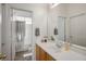 Bright and well-lit bathroom with a shower-tub combination, wooden vanity, and decorative plants at 5017 Kaibab Forest Ave, Las Vegas, NV 89141