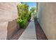 Narrow side yard showcasing stone walkway, brick wall and green landscaping at 5017 Kaibab Forest Ave, Las Vegas, NV 89141