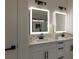 Modern bathroom featuring double vanity, illuminated mirrors, and sleek black hardware at 502 Edgefield Ridge Pl, Henderson, NV 89012