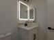 Bathroom vanity with decorative lighted mirror and sleek black hardware at 502 Edgefield Ridge Pl, Henderson, NV 89012