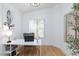 Well-lit home office with white desk, comfortable chair, and natural light from two large windows at 502 Edgefield Ridge Pl, Henderson, NV 89012