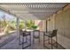 Cozy covered patio space with stylish bar-height seating, ideal for entertaining guests and relaxing at 502 Edgefield Ridge Pl, Henderson, NV 89012