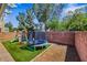 Landscaped backyard featuring artificial turf, a playground, and a trampoline, perfect for outdoor fun and entertainment at 5321 Welch Valley Ave, Las Vegas, NV 89131
