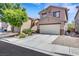 Exterior view of a two-story home featuring a spacious driveway, two-car garage, and desert landscaping at 5321 Welch Valley Ave, Las Vegas, NV 89131
