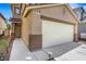 Close up of a two-story home featuring a two-car garage, and desert landscaping at 5321 Welch Valley Ave, Las Vegas, NV 89131