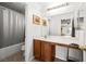 Bathroom features a shower-tub, dark cabinets, and a large mirror at 5456 Raccoon Valley Ln, Las Vegas, NV 89122
