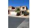 Two-story home featuring a desert landscape with a palm tree and a two-car garage at 5456 Raccoon Valley Ln, Las Vegas, NV 89122