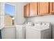Bright laundry room features full size washer and dryer with upper cabinets for storage at 5456 Raccoon Valley Ln, Las Vegas, NV 89122