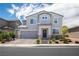 Beautiful two-story home with gray stucco, a brick driveway, manicured front yard, and a two-car garage at 5733 Coral Sun St, North Las Vegas, NV 89031