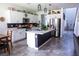 Modern kitchen with white cabinets, a central island, stainless steel appliances, and tiled floors at 5733 Coral Sun St, North Las Vegas, NV 89031