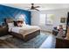 Stylish main bedroom with a decorative blue accent wall, ceiling fan, and comfortable furnishings at 5733 Coral Sun St, North Las Vegas, NV 89031