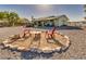 Outdoor fire pit area featuring mature landscaping, with relaxing backyard seating, and drought-resistant gravel at 6490 Wagon Wheel Ct, Pahrump, NV 89061
