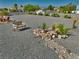 Landscaped backyard area featuring gravel, a rock garden, seating, and desert plants at 6490 Wagon Wheel Ct, Pahrump, NV 89061