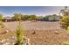 Spacious backyard with drought-tolerant landscaping, a cozy fire pit with chairs, and mature trees at 6490 Wagon Wheel Ct, Pahrump, NV 89061