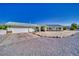Single story home with a detached garage has gravel yards, rock accents, and a concrete driveway at 6490 Wagon Wheel Ct, Pahrump, NV 89061