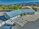 Aerial view of charming home with 3-car garage, desert landscaping, and mountain backdrop at 6490 Wagon Wheel Ct, Pahrump, NV 89061