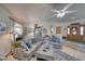 Bright living room with a grey sectional, wood-look floors and a ceiling fan is comfortable and inviting at 6490 Wagon Wheel Ct, Pahrump, NV 89061