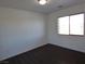 A well-lit bedroom featuring a large window and dark wood floors at 6604 Octave Ave, Las Vegas, NV 89139