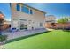 Backyard with artificial grass and brick-paved patio at 6790 Tangled Vines Ave, Las Vegas, NV 89139