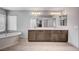 Bright bathroom boasts double vanity, soaking tub, and large mirror at 6790 Tangled Vines Ave, Las Vegas, NV 89139