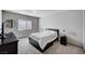 Neutral bedroom features a dark bed frame and a dresser at 6790 Tangled Vines Ave, Las Vegas, NV 89139