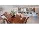 An elegant dining area with a large wooden table and a view of the kitchen at 6790 Tangled Vines Ave, Las Vegas, NV 89139