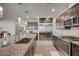 A stylish kitchen with granite countertops, stainless steel appliances, and sleek wood-look flooring at 6790 Tangled Vines Ave, Las Vegas, NV 89139